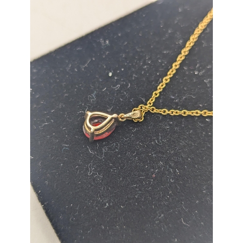 96 - A pear shaped garnet pendant in a three claw setting mounted in 9ct yellow gold on a 9ct yellow gold... 