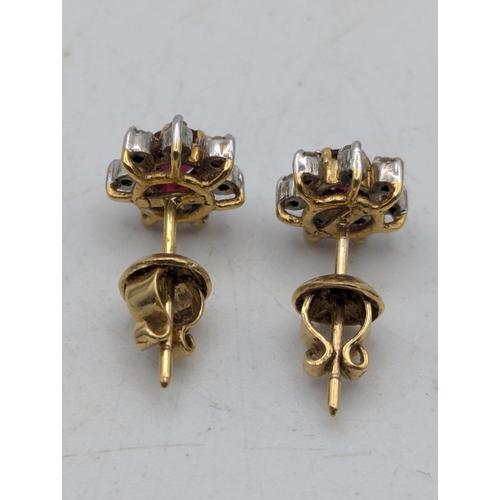 93 - A pair of ruby and diamond yellow metal stud earrings fashioned as a flower head, tested as 18ct gol... 