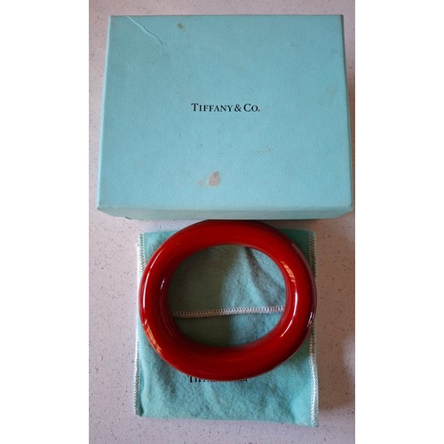 4 - Tiffany & Co- A red Elsa Peretti solid lacquered hardwood bangle with branded pouch and box, interna... 