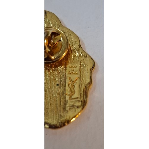 5 - YSL- A small lot comprising an Yves Saint Laurent gold tone leaf brooch, a gold tone Nina Ricci flor... 