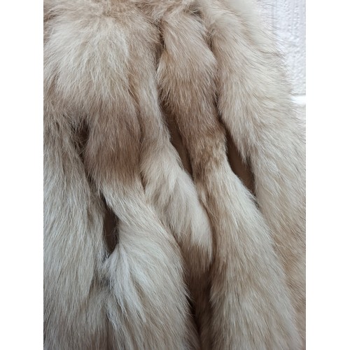 54 - A 1980's arctic fox jacket having intermittent vertical leather stripes, shawl collar and brown sati... 