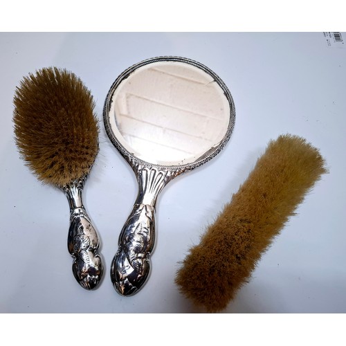 48 - A silver 2-piece dressing table set featuring a cherubic design together with a silver clothes brush... 