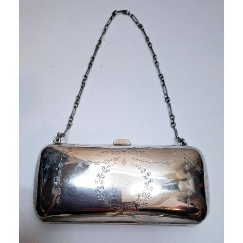 32 - An early 20th Century silver evening purse with green leather interior having hand engraved floral s... 
