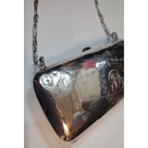 32 - An early 20th Century silver evening purse with green leather interior having hand engraved floral s... 