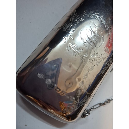 32 - An early 20th Century silver evening purse with green leather interior having hand engraved floral s... 