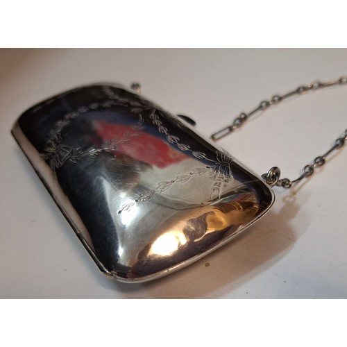 32 - An early 20th Century silver evening purse with green leather interior having hand engraved floral s... 