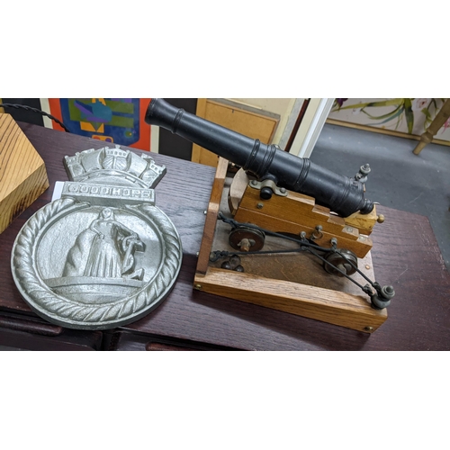 650 - A cast metal and wooden model canon, a cast iron Good Hope plaque and a brass fire-hose nozzle conve... 