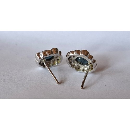 34 - A pair of 18ct white gold earrings stamped 750 having a central blue sapphire surrounded by illusion... 