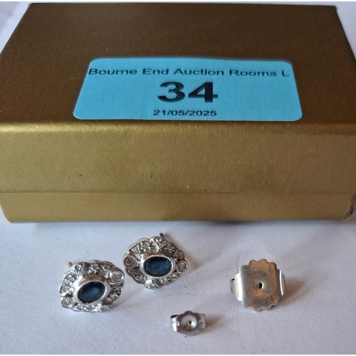 34 - A pair of 18ct white gold earrings stamped 750 having a central blue sapphire surrounded by illusion... 