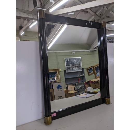 44 - A modern mirror in a black plastic rectangular frame with brass industrial style caps on each corner... 