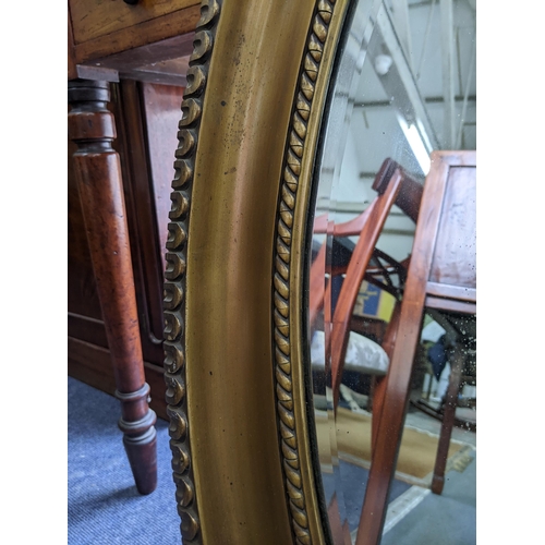 54 - An oval overmantle mirror with a gadrooned border rim supporting the bevelled glass plate
Location:R... 
