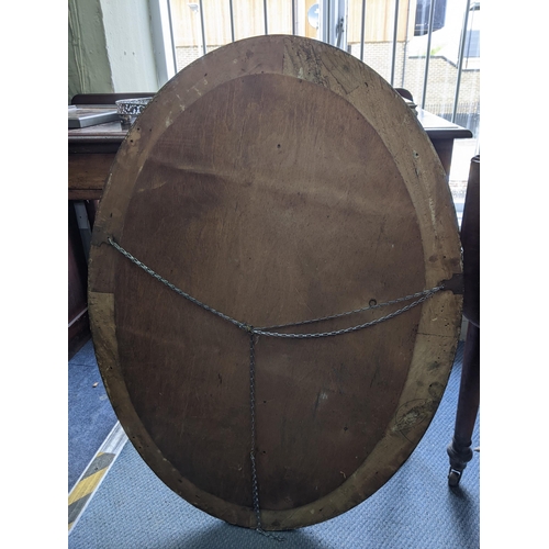 54 - An oval overmantle mirror with a gadrooned border rim supporting the bevelled glass plate
Location:R... 