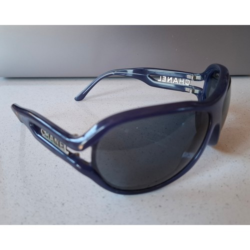 17 - Chanel-A pair of late 20th Century blue framed sunglasses with blue lenses and the Chanel name print... 