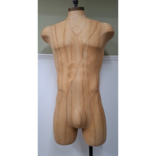 29 - An American Fusion USA tan calico shop mannequin/torso in male form on an adjustable cast metal base... 