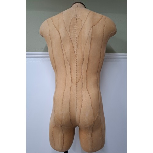 29 - An American Fusion USA tan calico shop mannequin/torso in male form on an adjustable cast metal base... 