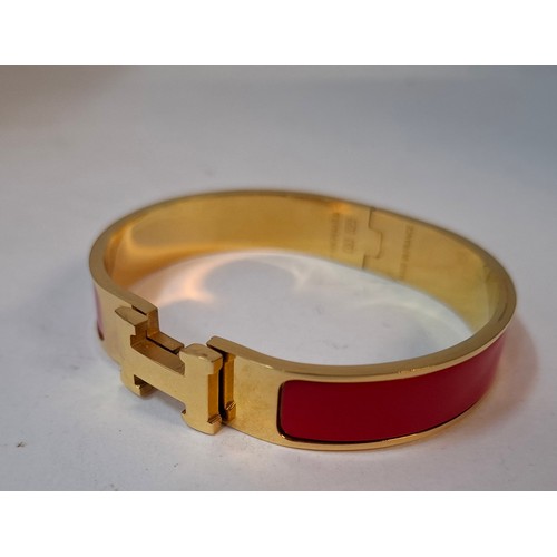 1A - Hermes- A 'Clic H' gold plated and red enamel bracelet, made in France, internal measurement 18cm. L... 