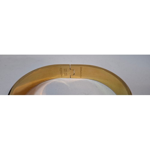 1A - Hermes- A 'Clic H' gold plated and red enamel bracelet, made in France, internal measurement 18cm. L... 