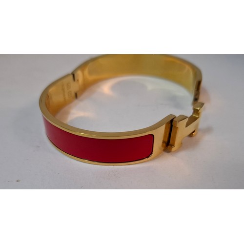1A - Hermes- A 'Clic H' gold plated and red enamel bracelet, made in France, internal measurement 18cm. L... 