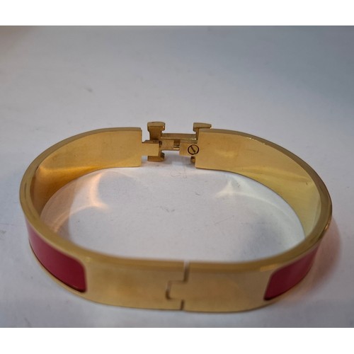 1A - Hermes- A 'Clic H' gold plated and red enamel bracelet, made in France, internal measurement 18cm. L... 