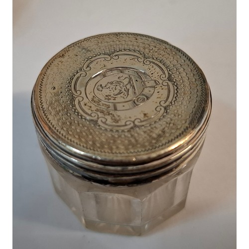 25 - Four silver dressing table items comprising 2 glass pots with silver lids, a circa 1900 silver embos... 