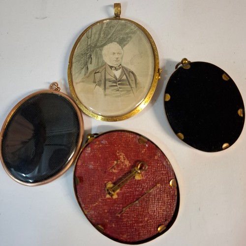 27 - A large Victorian Pinchbeck framed mourning pendant depicting a portrait of an elderly gent, the rev... 