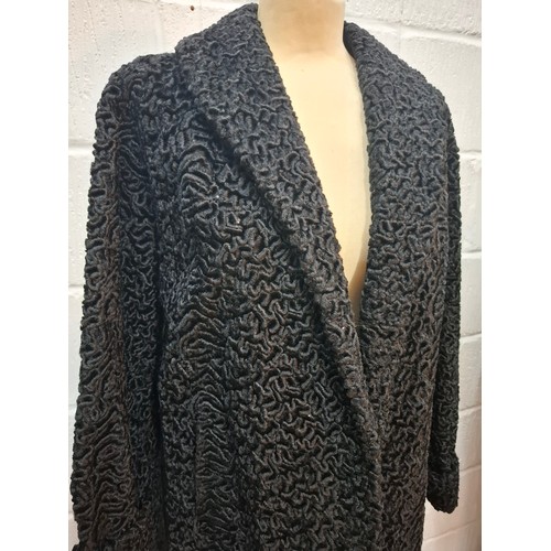 49 - A vintage black astrakhan swing coat, approx 40