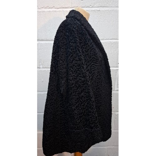 49 - A vintage black astrakhan swing coat, approx 40