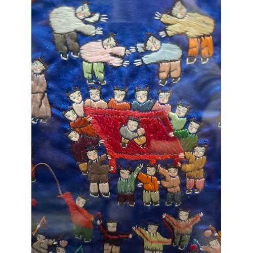 41 - Four framed Oriental embroidered silk panels to include a pair of Chinese blue silk panels depicting... 