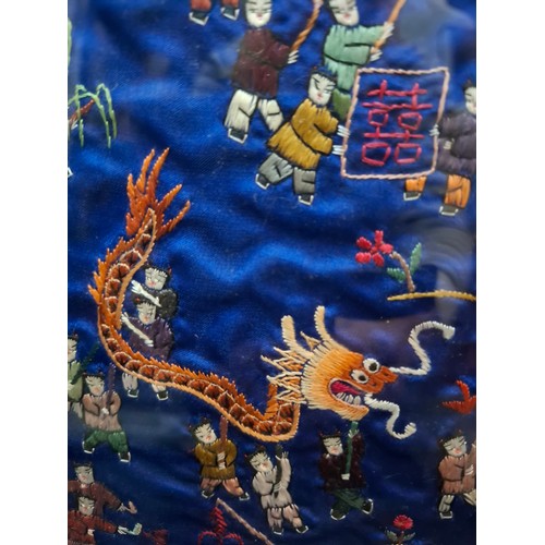 41 - Four framed Oriental embroidered silk panels to include a pair of Chinese blue silk panels depicting... 