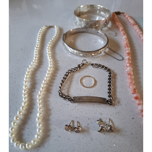 18 - A pearl necklace having a 9ct gold clasp stamped 375, 2 silver hinged bangles, a coral necklace with... 