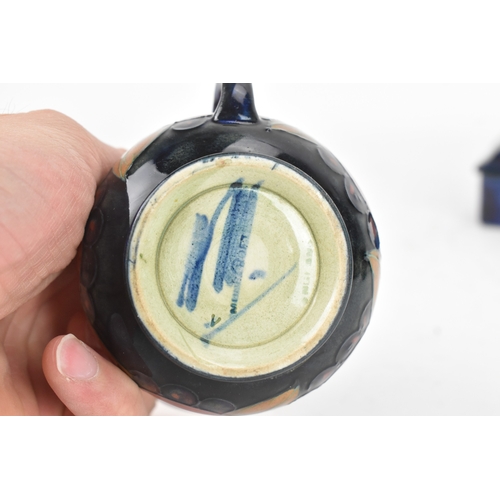 104 - A group of early/mid 20th century Moorcroft pottery to include a 'pomegranate' patter pewter mounted... 