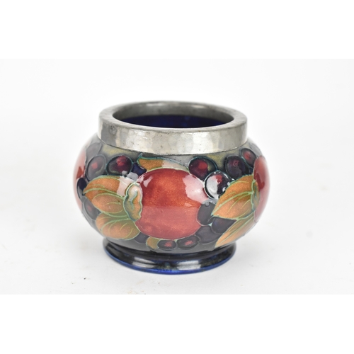 104 - A group of early/mid 20th century Moorcroft pottery to include a 'pomegranate' patter pewter mounted... 