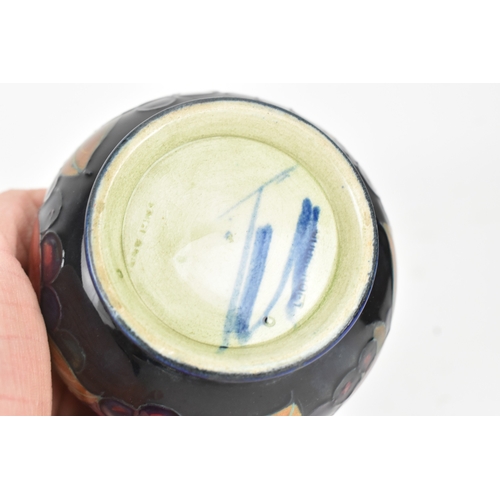 104 - A group of early/mid 20th century Moorcroft pottery to include a 'pomegranate' patter pewter mounted... 