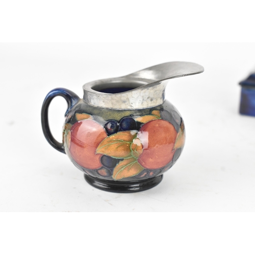 104 - A group of early/mid 20th century Moorcroft pottery to include a 'pomegranate' patter pewter mounted... 