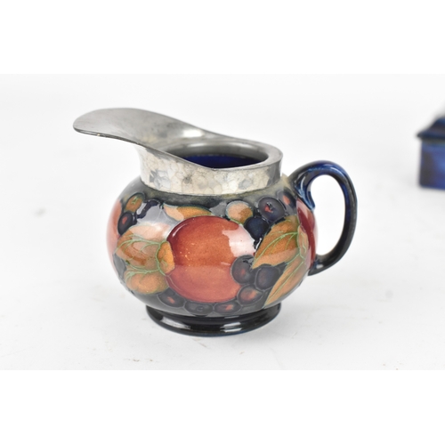 104 - A group of early/mid 20th century Moorcroft pottery to include a 'pomegranate' patter pewter mounted... 