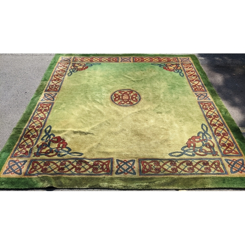 207 - An early 20th century hand-knotted Donegal carpet, the green field centred by a red and blue knotwor... 