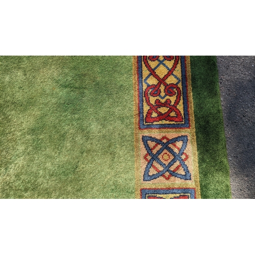 207 - An early 20th century hand-knotted Donegal carpet, the green field centred by a red and blue knotwor... 