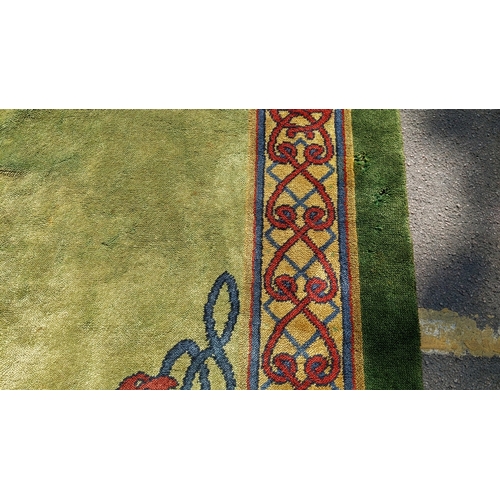 207 - An early 20th century hand-knotted Donegal carpet, the green field centred by a red and blue knotwor... 