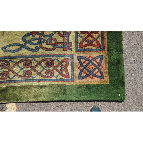 207 - An early 20th century hand-knotted Donegal carpet, the green field centred by a red and blue knotwor... 