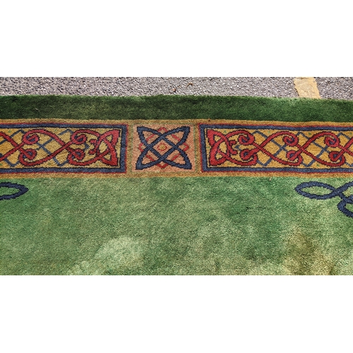 207 - An early 20th century hand-knotted Donegal carpet, the green field centred by a red and blue knotwor... 