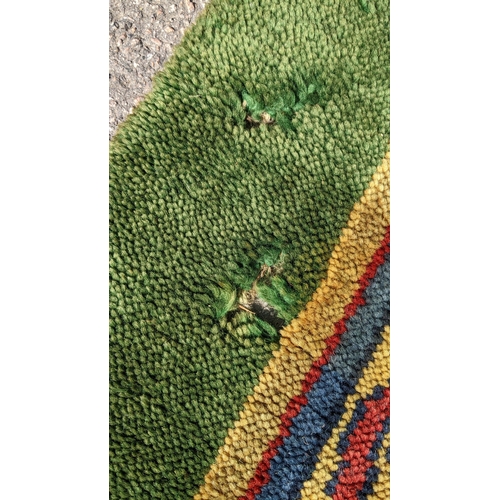 207 - An early 20th century hand-knotted Donegal carpet, the green field centred by a red and blue knotwor... 