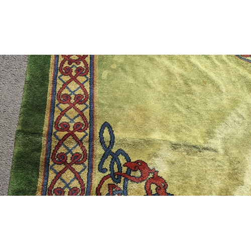 207 - An early 20th century hand-knotted Donegal carpet, the green field centred by a red and blue knotwor... 