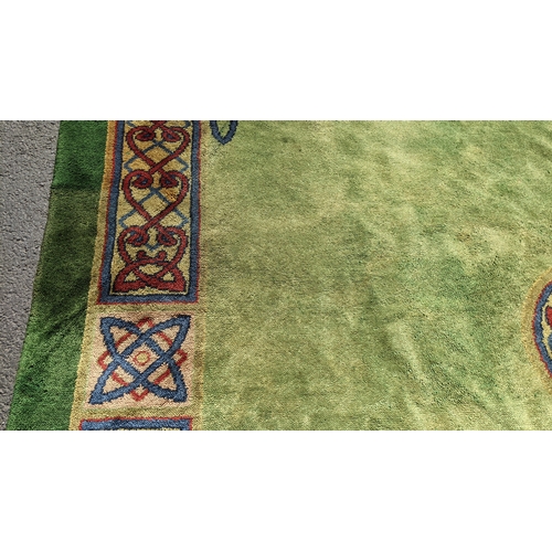 207 - An early 20th century hand-knotted Donegal carpet, the green field centred by a red and blue knotwor... 