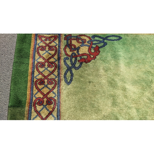 207 - An early 20th century hand-knotted Donegal carpet, the green field centred by a red and blue knotwor... 