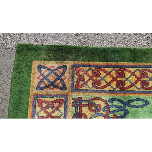 207 - An early 20th century hand-knotted Donegal carpet, the green field centred by a red and blue knotwor... 
