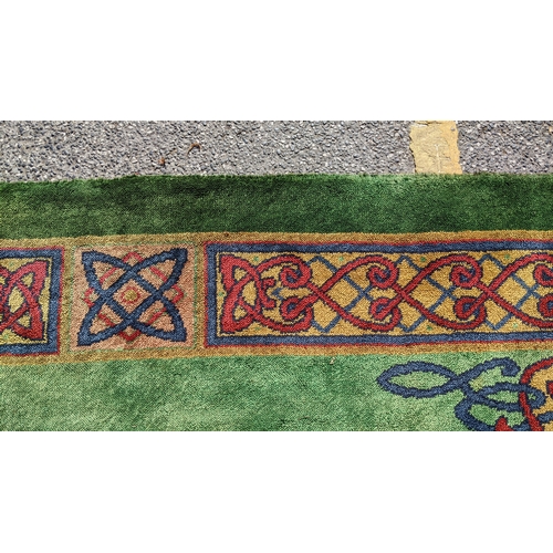 207 - An early 20th century hand-knotted Donegal carpet, the green field centred by a red and blue knotwor... 