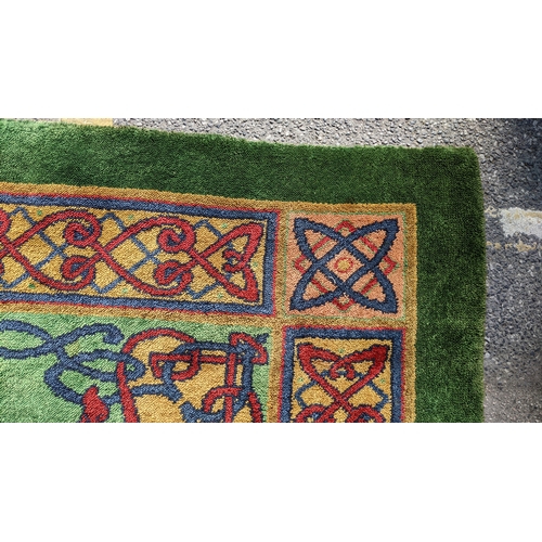 207 - An early 20th century hand-knotted Donegal carpet, the green field centred by a red and blue knotwor... 