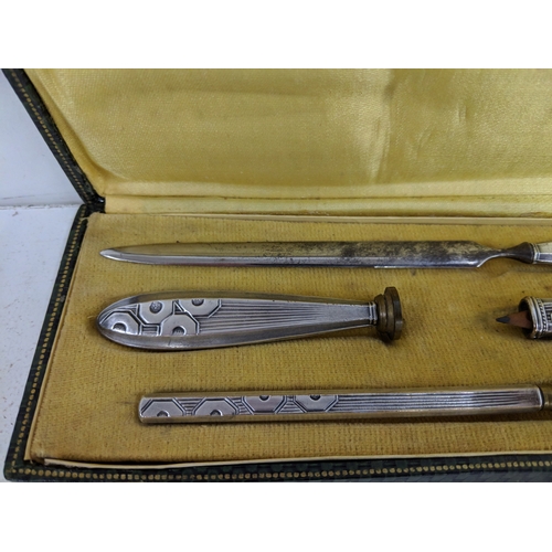 22 - Circa 1925 a French silver plated cased desk set to include a letter opener, a seal, a silver cased ... 