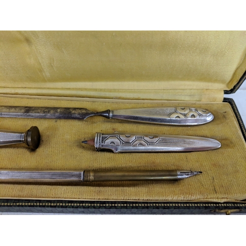 22 - Circa 1925 a French silver plated cased desk set to include a letter opener, a seal, a silver cased ... 