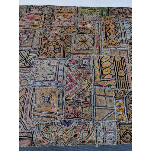 54 - An oriental style wall hanging with a variety of abstract patterns on a hanging pole 148 cm H x 72 c... 